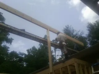 Carpenter setting a ridge beam over a new addition frame — Ice Dam Removal by Roofing Brothers in Hamshire