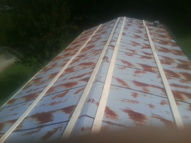 Rusted metal roof panels with new wood purlins before replacement — Storm Damage Roof Repair in Hamshire by Roofing Brothers