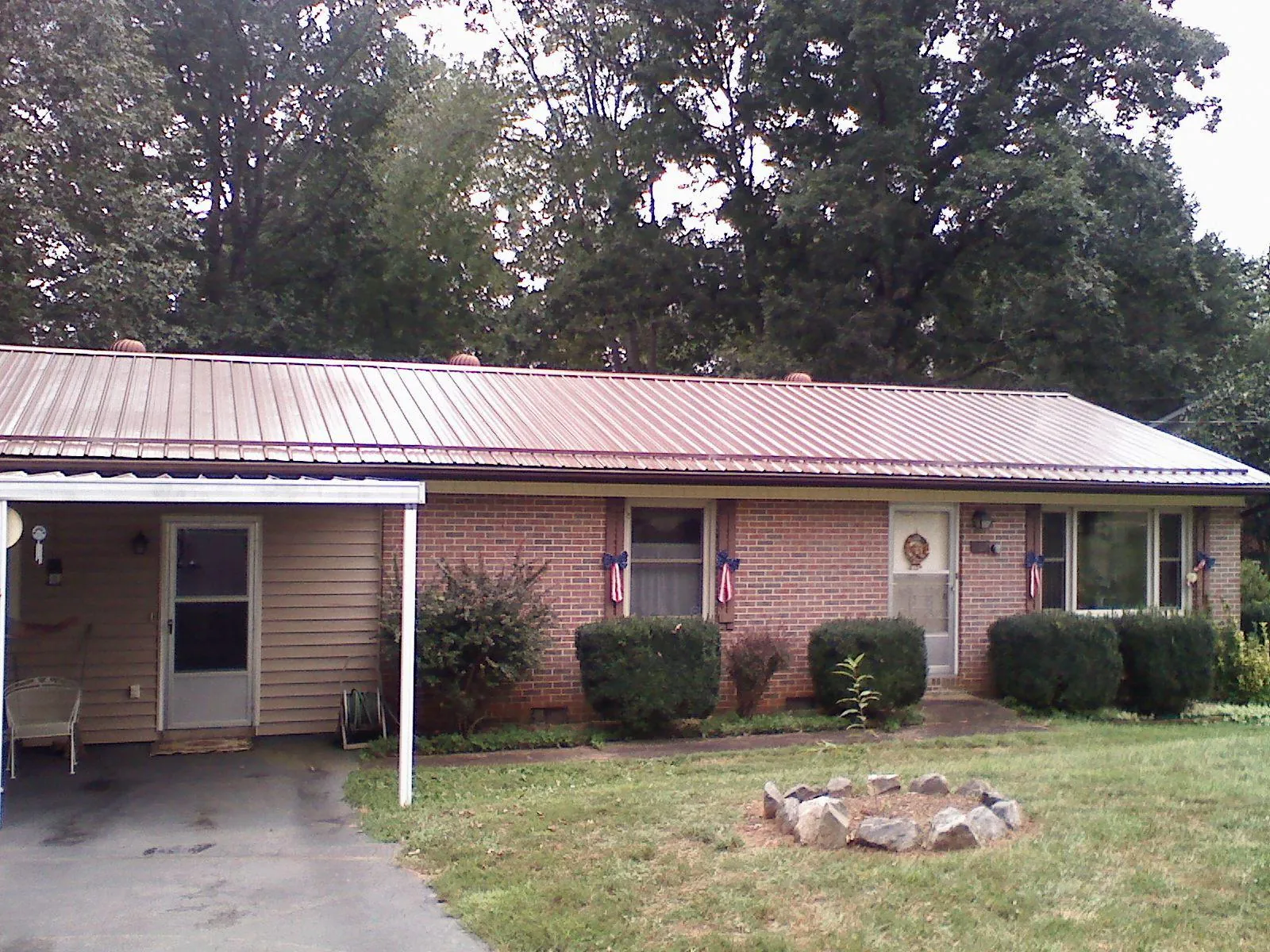 Bronze metal roof and carport on a brick ranch home — Roof Repair work by our crew in Hamshire
